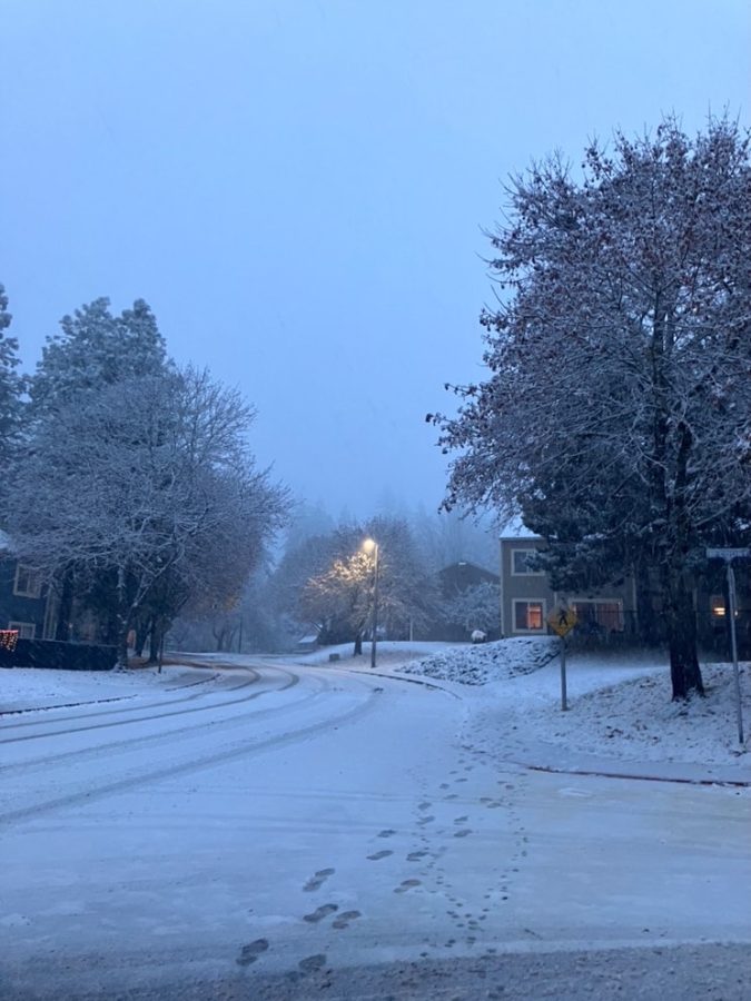 An image of a snow covered road in Lake Stevens, acting as a perfect symbol for the very beginning of Winter. The snowing footsteps getting smaller and smaller, fading away, representing summer leaving and winter arriving. 