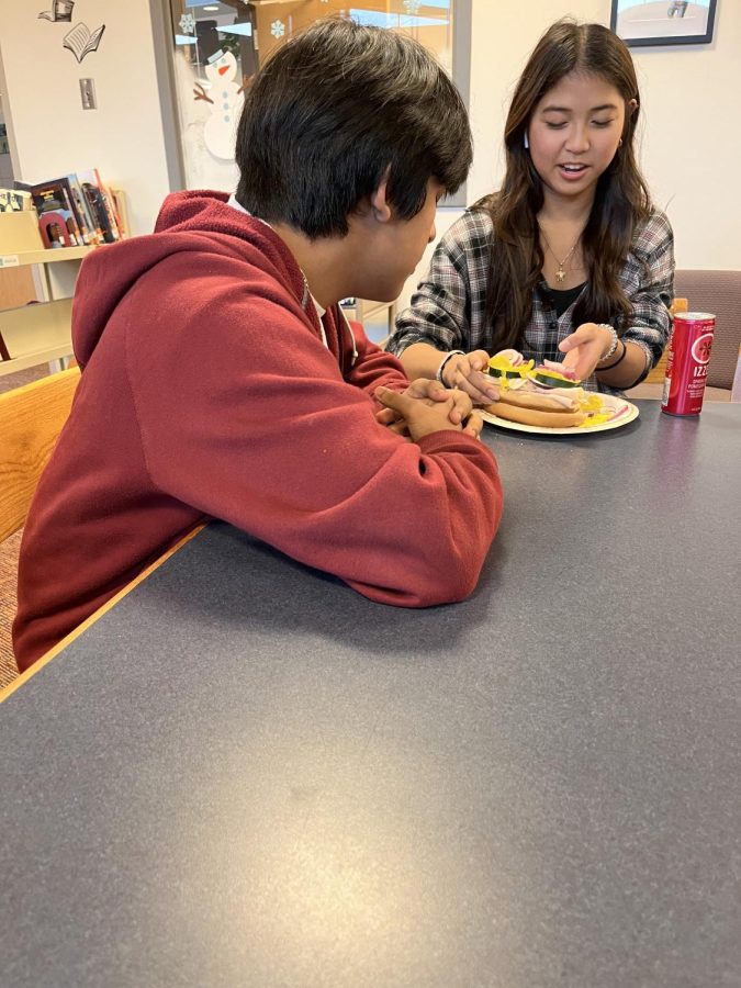 After eating a slice of pizza at lunch, Student Jorge Gonzalez-Miranda is tempted to eat Isa Ha’ani San Luis’s sandwich. (December 9th 2022 Nickolas Jenkins Morales)
