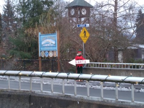 An animatronic elf flashes a sign showing in which direction Santa can be found. They’re all around Main Street Lake Stevens. These festive robotic elves feel like a map in which can find your childhood joy. 