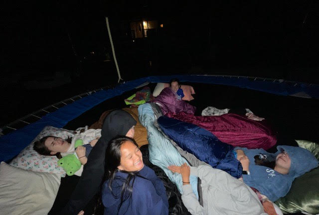A group of friends spend a night under the stars sleeping together on a trampoline that ended up being more snug than they originally thought. In the picture some people are trying to get their beauty rest while others are doing more hyperactive things. A friend says, “It felt like we were a human pretzel.” (Juliana Manley). 