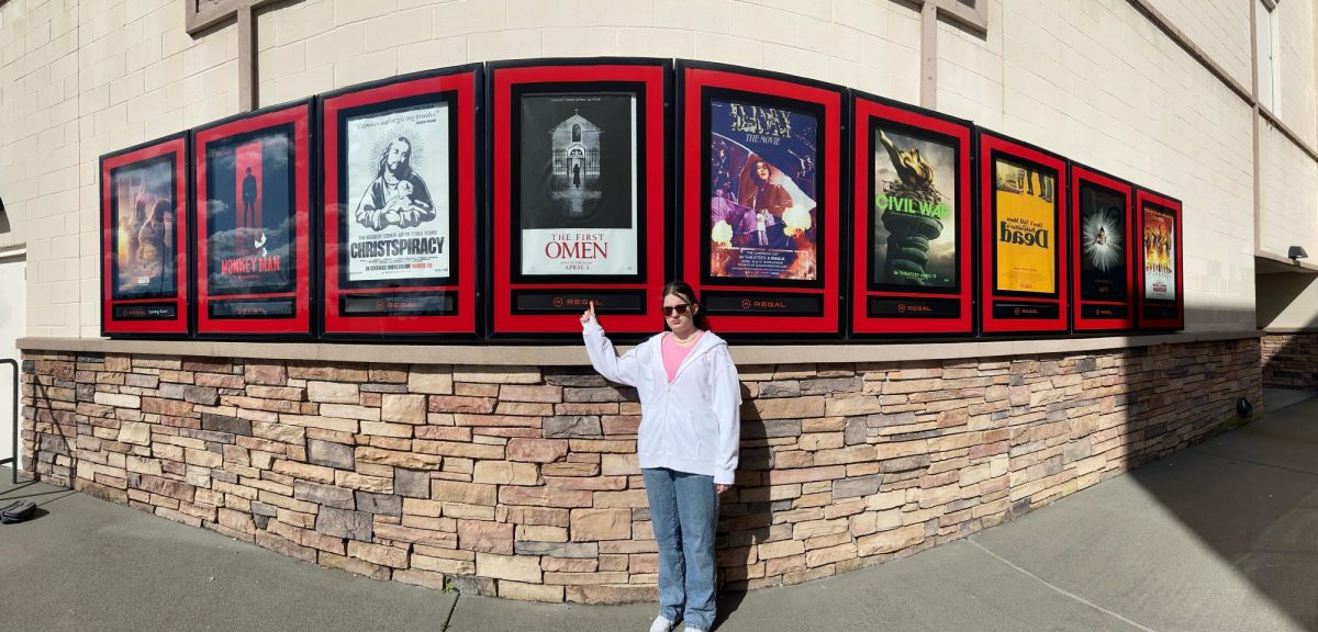 Me, disappointed, posing in front of posters for movies Ive never seen. 